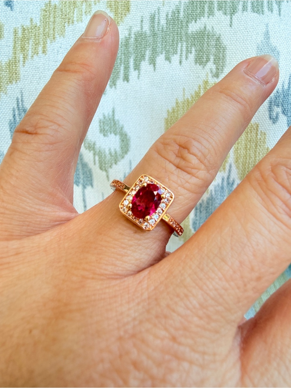 Rose Gold Ring with Deep Red Oval Gemstone and Halo